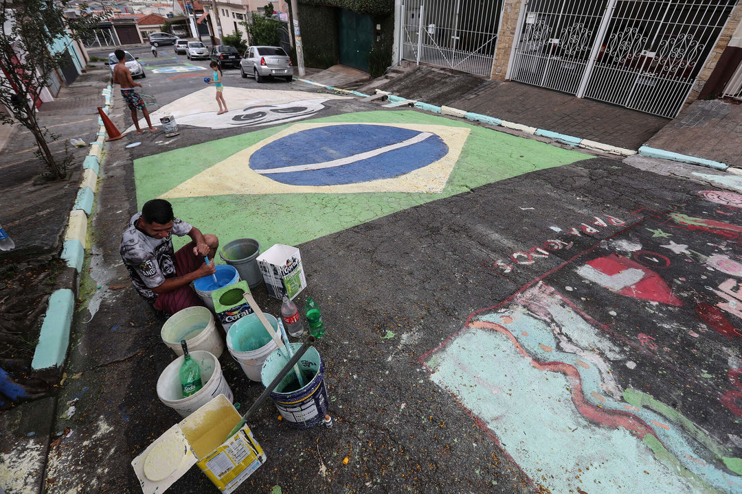 <p>Los brasileños pintan una calle con los colores verde y amarillo del escudo. EFE/ Sebastián Moreira</p>