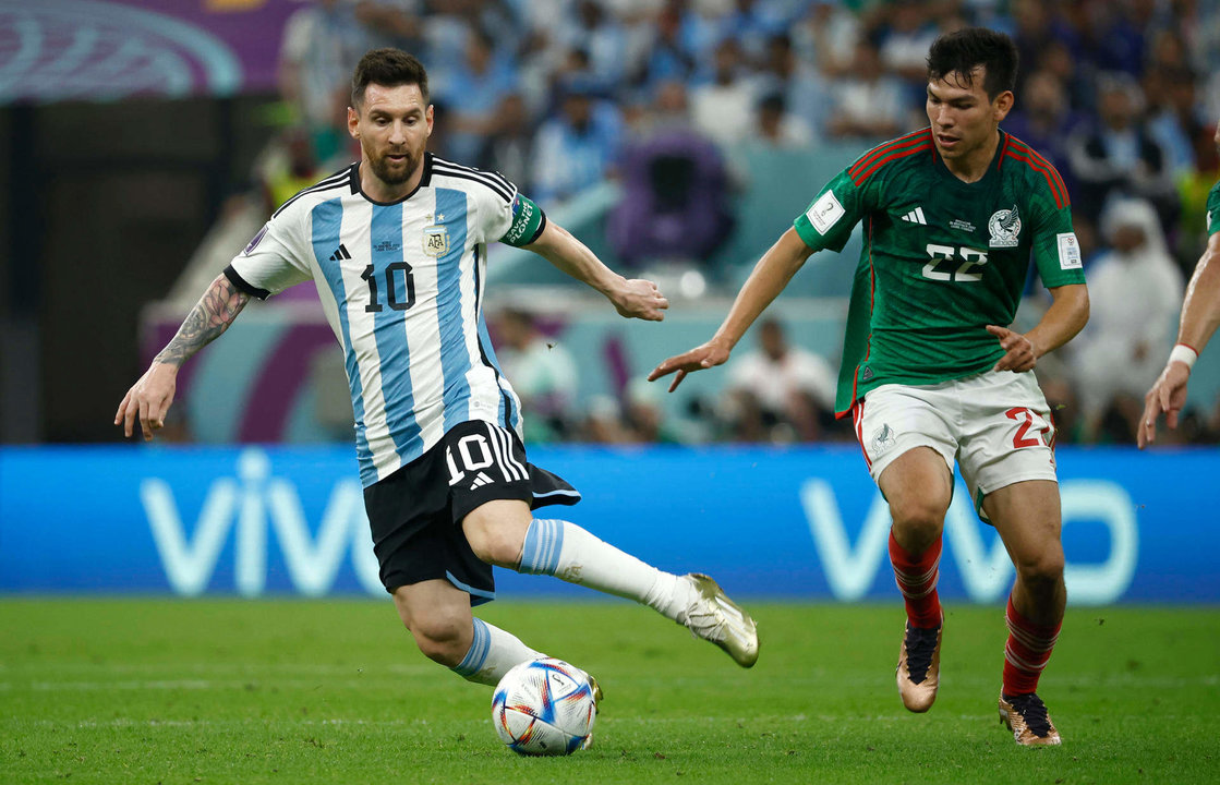 Lionel Messi (i) de Argentina disputa un balón con Hirving Lozano de México hoy, en un partido de la fase de grupos del Mundial de Fútbol Qatar 2022 entre Argentina y México en el estadio de Lusail (Catar). EFE/José Méndez