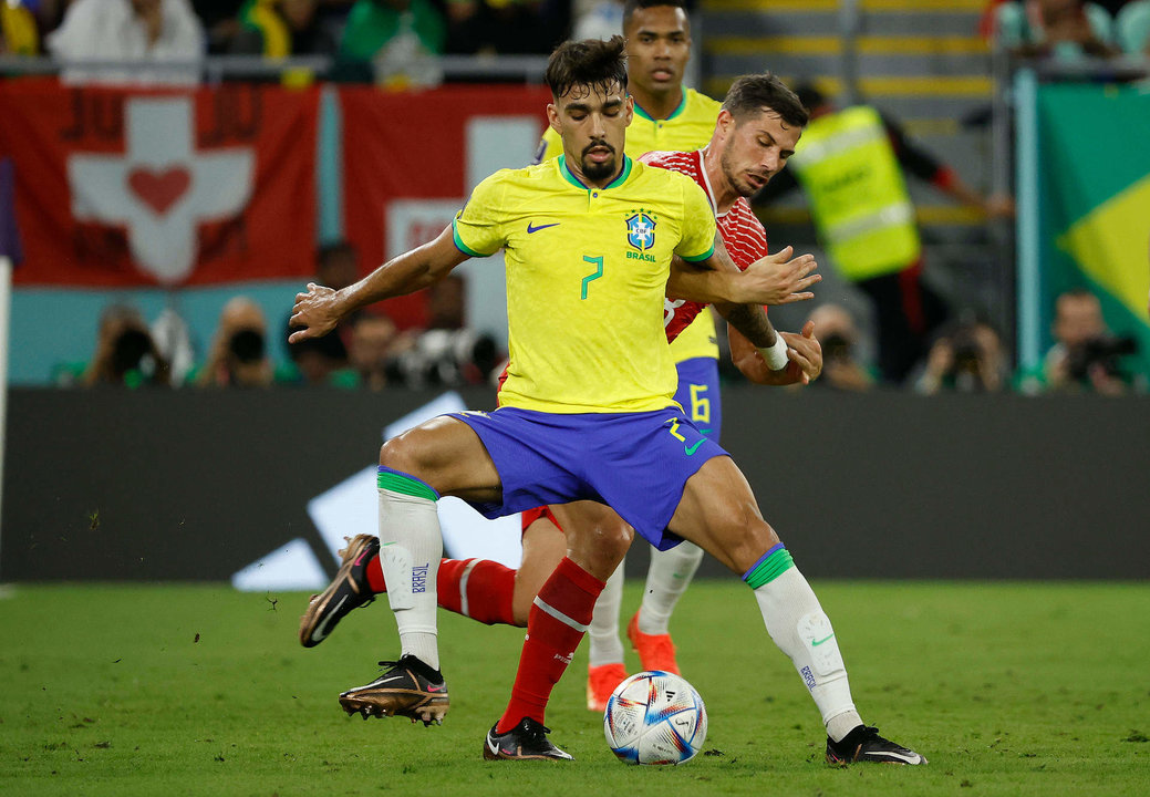 Lucas Paquetá (adelante) de Brasil disputa un balón con Remo Freuler de Suiza  hoy, en un partido de la fase de grupos del Mundial de Fútbol Qatar 2022 entre Brasil y Suiza en el estadio 974 en Doha (Catar). EFE/José Méndez