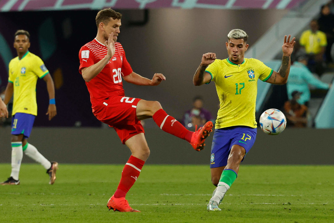 Bruno Guimaraes (d) de Brasil disputa un balón con Fabian Frei de Suiza  hoy, en un partido de la fase de grupos del Mundial de Fútbol Qatar 2022 entre Brasil y Suiza en el estadio 974 en Doha (Catar). EFE/ JJ Guillén