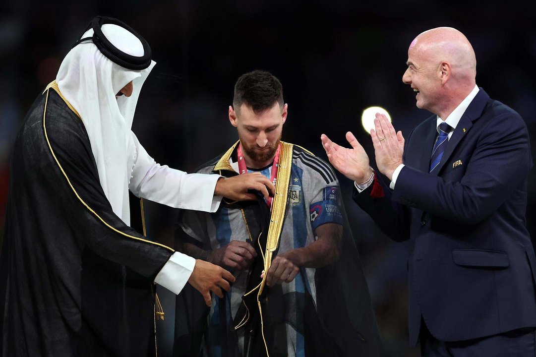 El emir de Catar, Tamim bin Hamad Al Thani, coloca a Leo Messi el 'bisht', la capa tradicional en Oriente Medio, antes de levantar el título de la Copa el Mundo. EFE/EPA/Tolga Bozoglu